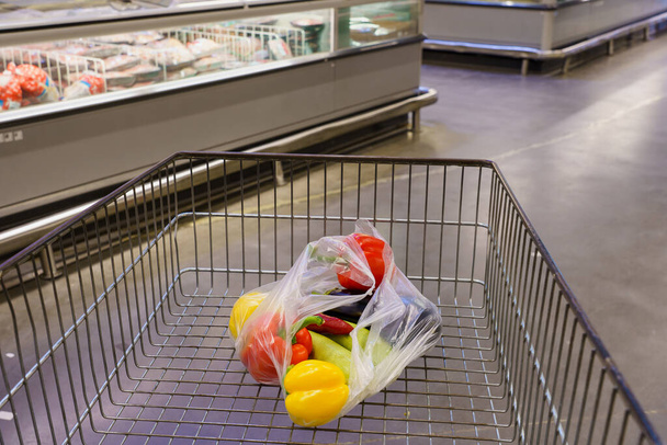 Zöldségek egy bevásárlókocsiban. Háttér szelektív fókusszal és szövegmásolási lehetőséggel. - Fotó, kép