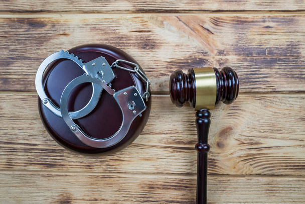 Суддя подарував наручники на дерев'яному тлі
 - Фото, зображення
