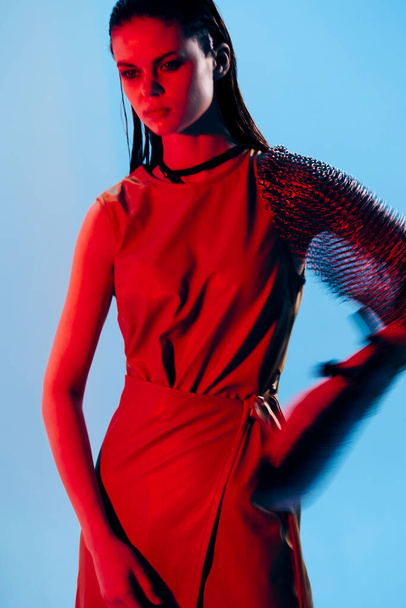 όμορφη γυναίκα κόκκινο φως ασημένια πανοπλία αλυσίδα ταχυδρομείου μόδας απομονωμένη φόντο. Υψηλής ποιότητας φωτογραφία - Φωτογραφία, εικόνα