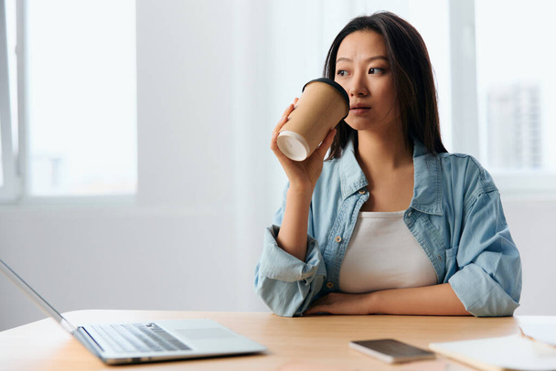 挫折感のある若いアジア系の可愛い実業家たちが、オフィスの中でコーヒーカップを開催します。フリーランスは自宅で働いています。レディー・コーポレーションのリーダーコンセプト。コピースペースの提供 - 写真・画像