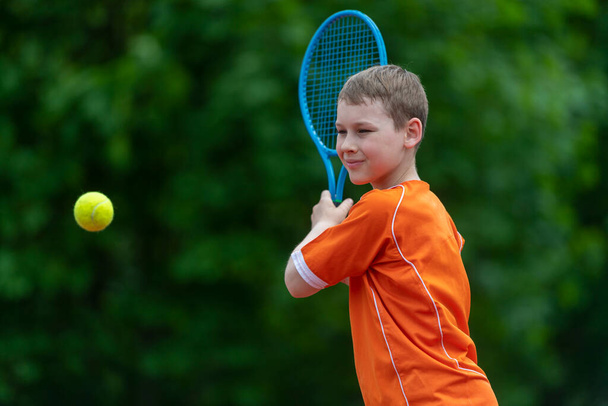 Criança com raquete de ténis no campo de ténis. Treinamento para crianças pequenas, crianças saudáveis. Horizontal esporte tema cartaz, cartões de saudação, cabeçalhos, site e app - Foto, Imagem