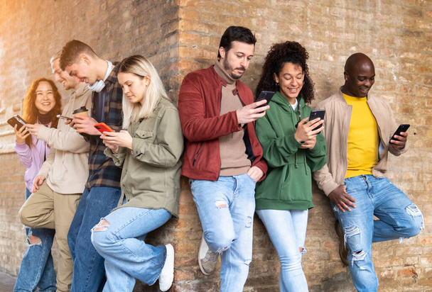 Multiracionális baráti csoport okostelefonokat használ a tartalmak megosztására a közösségi oldalakon. Technológiai életmód koncepció - szelektív fókusz - Fotó, kép
