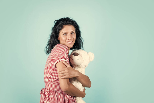 smiling female with trendy clothes play with teddy bear toy, joy. - Zdjęcie, obraz