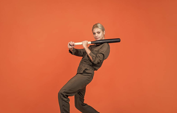 in motion. woman in boilersuit with bat. female baseball player. sports and games. cricket player on orange background. lady girl holding sport equipment or accessory. active wear. rounders game. - Foto, Imagen