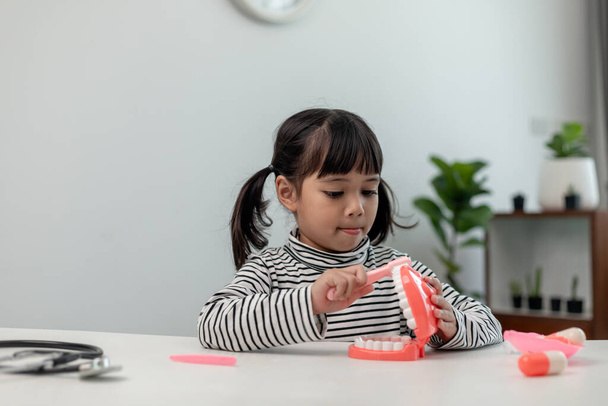 Un petit enfant joue avec des mâchoires artificielles. Dentisterie pour enfants. - Photo, image
