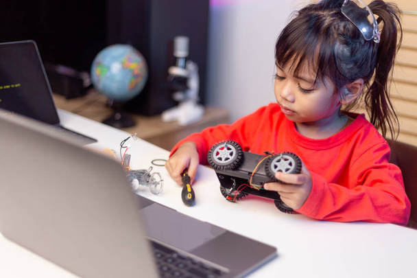 Los estudiantes de Asia aprenden en casa en la codificación de automóviles robóticos y cables de placas electrónicas en STEM, STEAM, matemática ingeniería tecnología código informático en robótica para niños concepto. - Foto, imagen