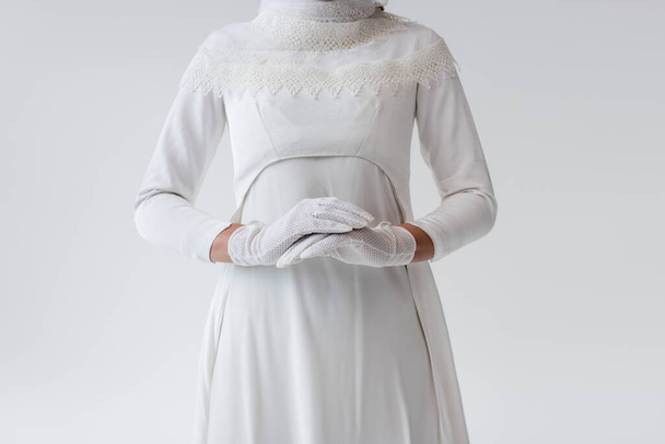 cropped view of bride in gloves and wedding dress isolated on grey - Valokuva, kuva