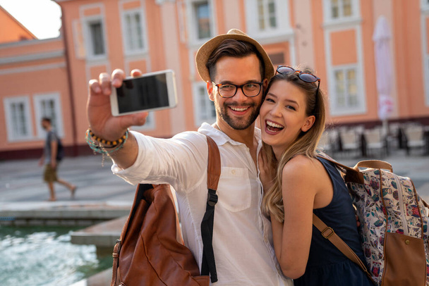 Happy tourist couple in love having fun, traveling smiling together on vacation. People happiness concept. - 写真・画像