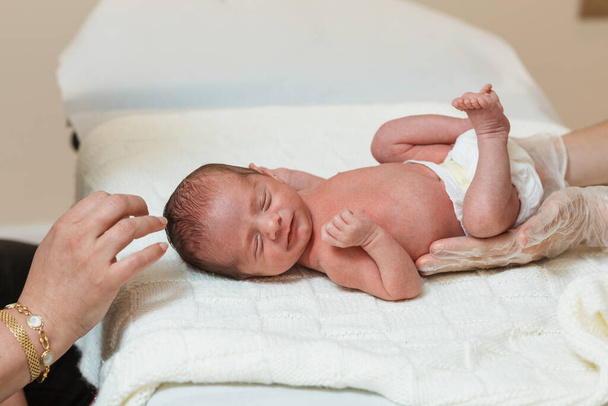 Παιδιατρική φυσιοθεραπευτής εκτελεί μια αξιολόγηση της πρωτογενούς αναπνευστικής κίνησης σε ένα νεογέννητο μωρό. Ιατρική έννοια. - Φωτογραφία, εικόνα
