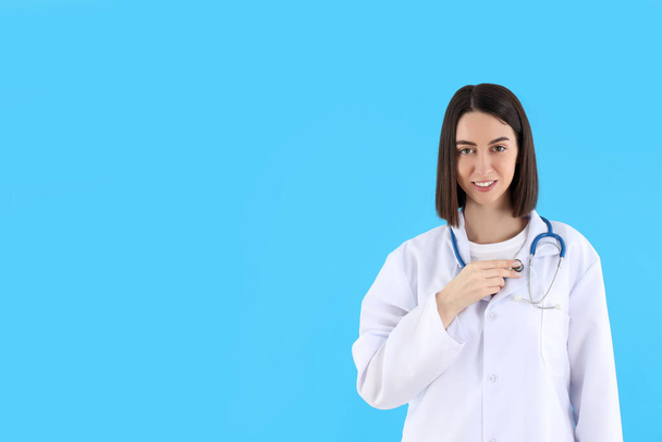 Atractiva joven doctora sobre fondo azul
 - Foto, Imagen