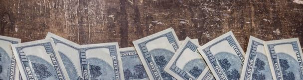 100 dolarlık banknotlar kahverengi bir masaya dizilmişti. - Fotoğraf, Görsel