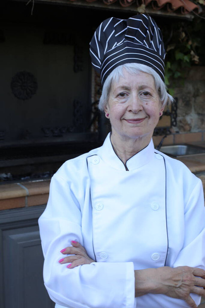 retrato de cerca de mujer madura en uniforme de chef con sombrero - Foto, Imagen