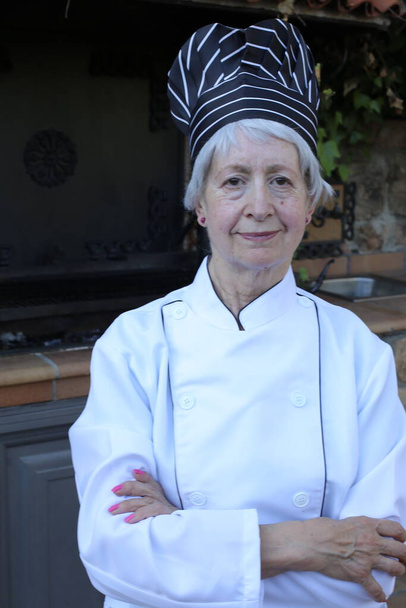portret dojrzałej kobiety w mundurze szefa kuchni z kapeluszem - Zdjęcie, obraz