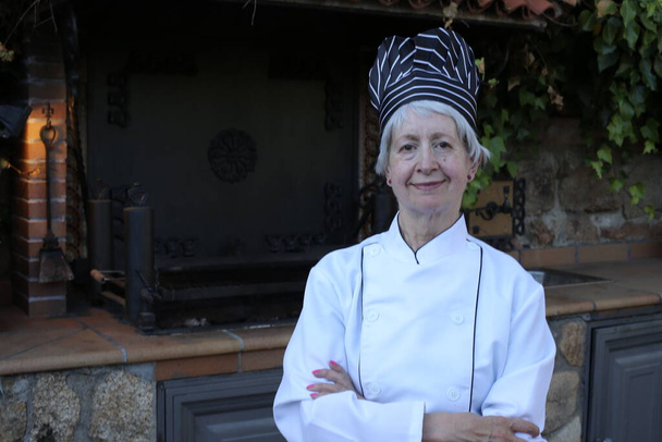 close-up portrait of mature woman in chef uniform with hat - Photo, Image
