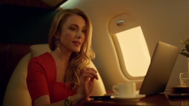 Cheerful businesswoman chatting online on private jet closeup. Remote workplace. Beautiful lady boss videocalling business partner on corporate trip. Smiling executive working talk on virtual meeting - Footage, Video