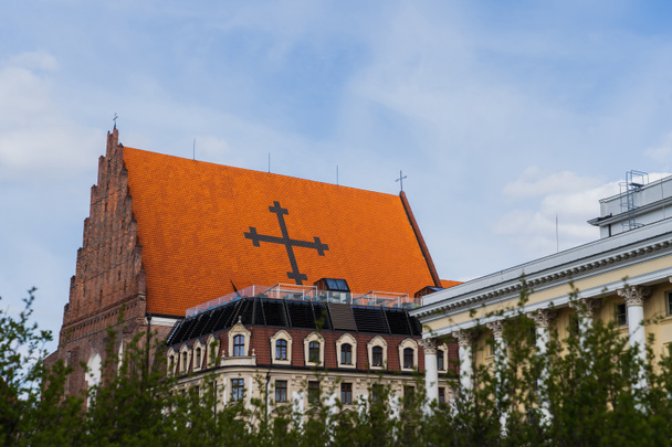 Kościół św. Doroty w pobliżu budynków i niewyraźne krzaki we Wrocławiu - Zdjęcie, obraz