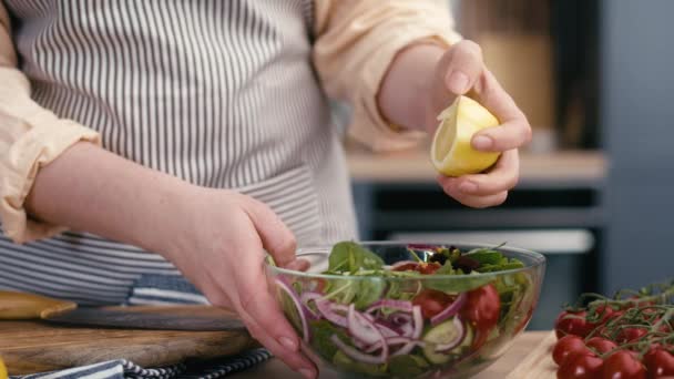 Nahaufnahme einer Frau, die Zitrone für den Salat auspresst. Aufnahme mit roter Heliumkamera in 4K.  - Filmmaterial, Video