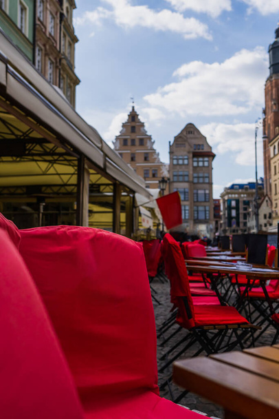 Chairs and tables near outdoors cafe on urban street in Wroclaw - Foto, imagen