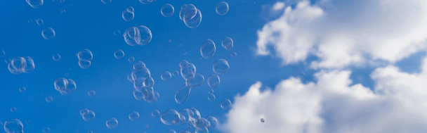Niedriger Blickwinkel auf Seifenblasen mit Himmel im Hintergrund, Banner  - Foto, Bild