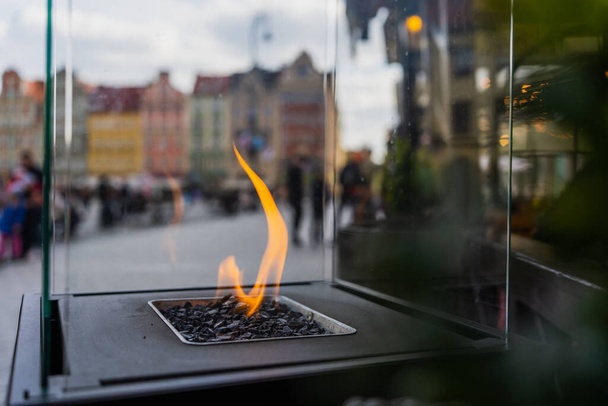 Close up view of fire in glass box on blurred street in Wroclaw - Foto, afbeelding