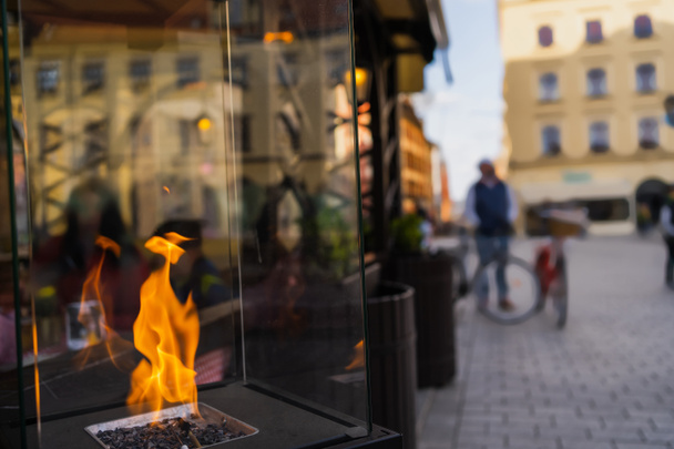 Fire in glass box on blurred urban street in Wroclaw - Photo, Image