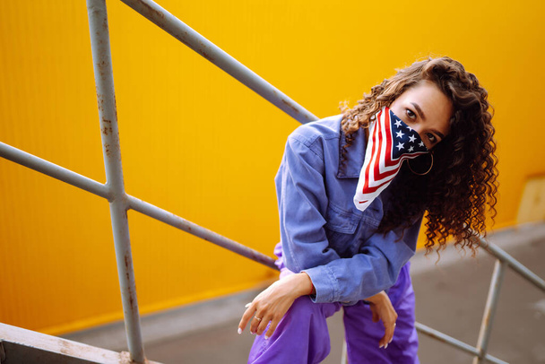 Dançarina de rua em roupas elegantes com bandana americana dançando e mostrando alguns movimentos. Conceito de esporte, dança e cultura urbana. - Foto, Imagem