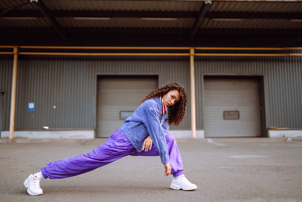Street dancer in stylish clothes dancing and showing some moves. Sport, dancing and urban culture concept. - Photo, Image