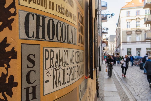 WROCLAW, POLAND - APRIL 18, 2022: Advertising lettering on facade of building on urban street  - Фото, зображення