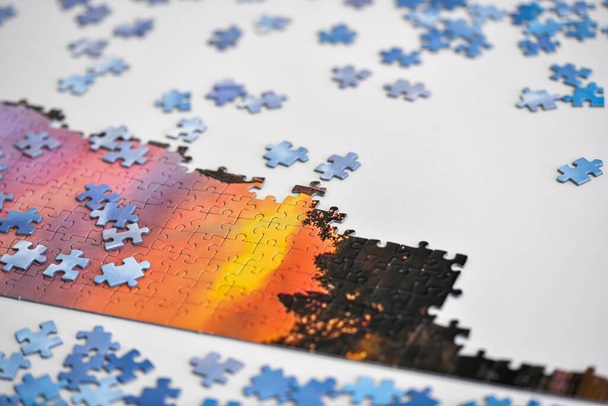 Parte dell'immagine assemblata da puzzle su un tavolo bianco. - Foto, immagini