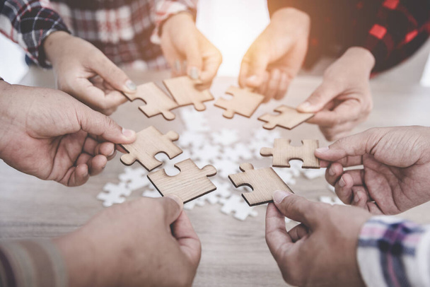 Group of business people assemble jigsaw puzzles, concepts of cooperation, teamwork, help and support in business, symbol of association and connection. business strategy. - 写真・画像