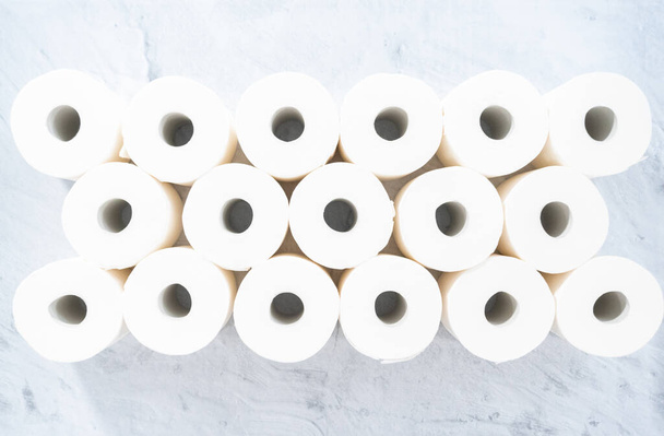 Flat lay. New white toilet paper rolls on a gray background. - Photo, Image