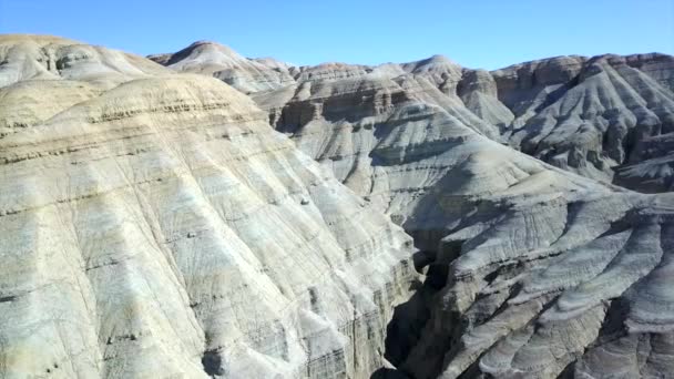 Colored mountains of Aktau in the steppe. Limestone mountains in the middle of the desert. Colored hills from white to red. The earths rock is separated by layers. A huge canyon. Altyn Emel. - Footage, Video
