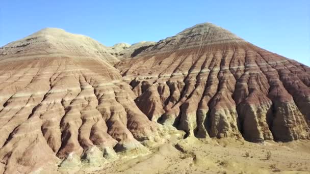 Montagnes colorées d'Aktau dans la steppe. Montagnes calcaires au milieu du désert. Collines colorées du blanc au rouge. La roche terrestre est séparée par des couches. Un énorme canyon. Altyn Emel. - Séquence, vidéo