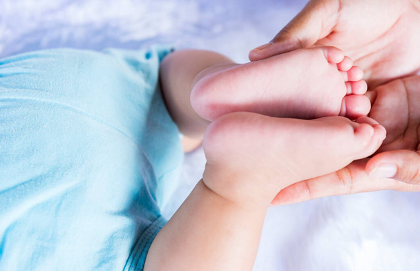 Babyfüße in den Händen des Vaters. Winzige Beine eines neugeborenen Babys auf männlichen Händen, in Großaufnahme. Das Konzept einer glücklichen Familie. Vatertag - Foto, Bild
