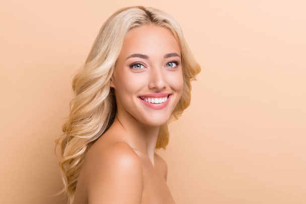 Profile side view portrait of attractive cheerful wavy-haired woman shine suntan copy space isolated over beige pastel color background. - Foto, immagini