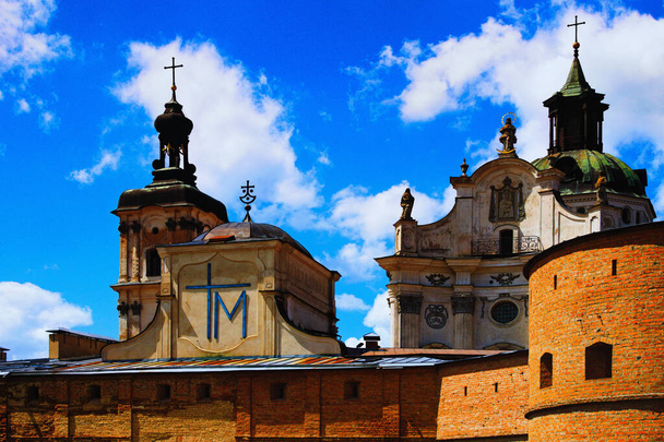 Szcenírozott táj kilátás nyílik a kolostor a discalced karmeliták. Keresztény ortodox katedrális. Kék ég fehér felhőkkel a háttérben. Berdychiv, Ukrajna. - Fotó, kép