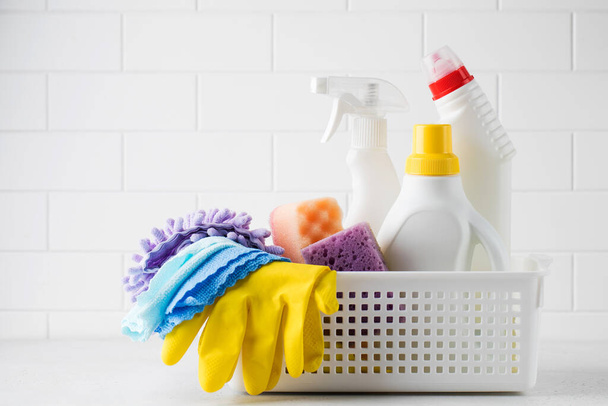  Cleaning products for cleaning, disinfection at home in a basket on a light background. The concept of a cleaner, cleaning company.  - Zdjęcie, obraz