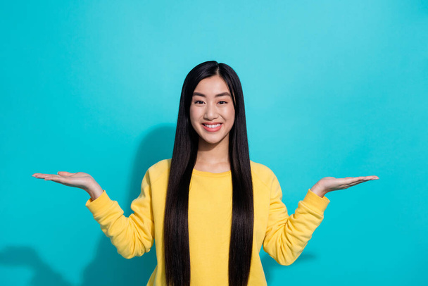 Photo of sweet shiny woman wear yellow pullover showing arms alternative empty space isolated teal color background. - Фото, зображення