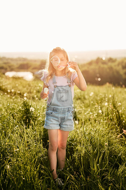 Caucásico chica jugando con burbujas en el prado   - Foto, Imagen