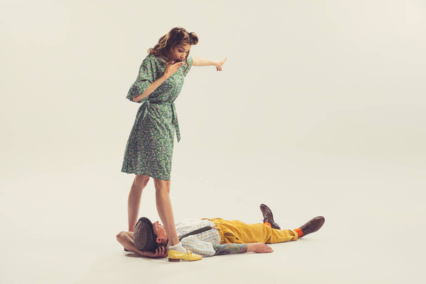 Wow. Studio shot of young man and girl in vintage retro style outfits psoing isolated on white background. Concept of relations, family, 1960s american fashion style and art. Couple look emotional - Фото, изображение