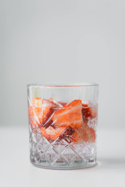 close up view of glass with fresh strawberry tonic on white surface isolated on grey - Photo, Image