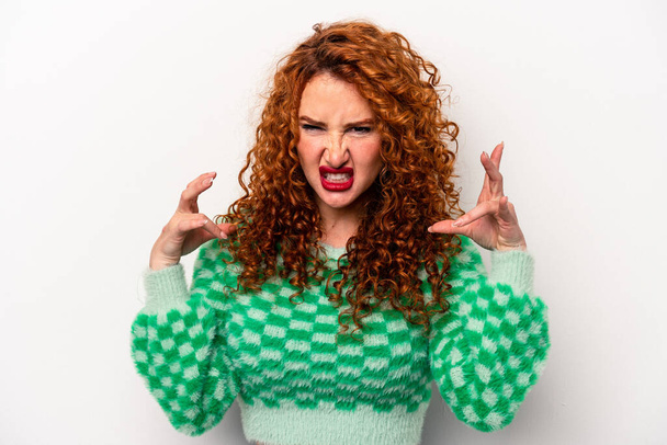 Young ginger caucasian woman isolated on white background screaming with rage. - 写真・画像