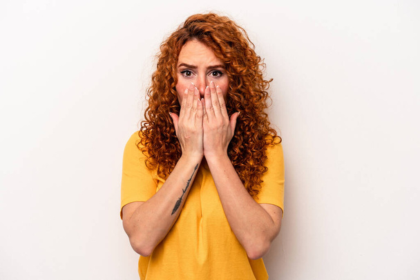 Young ginger caucasian woman isolated on white background shocked, covering mouth with hands, anxious to discover something new. - Foto, Imagen
