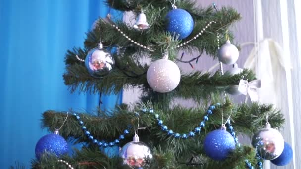 A karácsonyfát kék és ezüst karácsonyi játékokkal díszítik. - Felvétel, videó