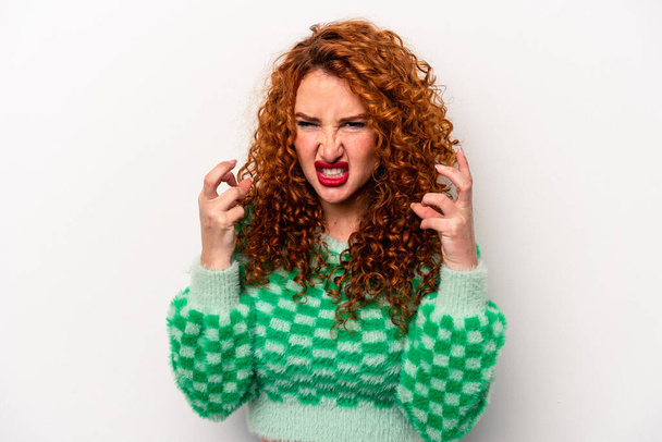 Young ginger caucasian woman isolated on white background upset screaming with tense hands. - Foto, immagini