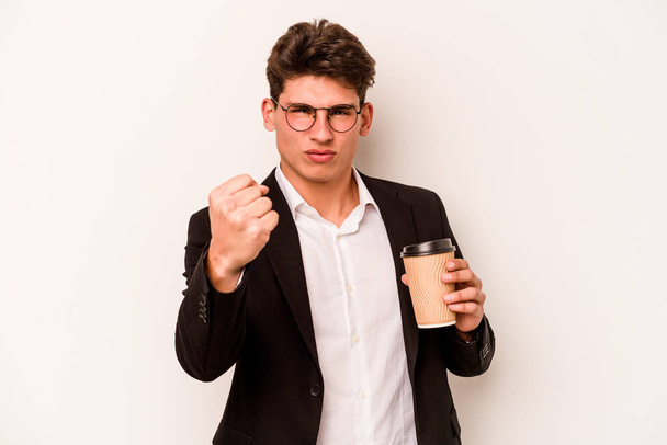 Young caucasian business man holding takeaway coffee isolated on white background showing fist to camera, aggressive facial expression. - Φωτογραφία, εικόνα