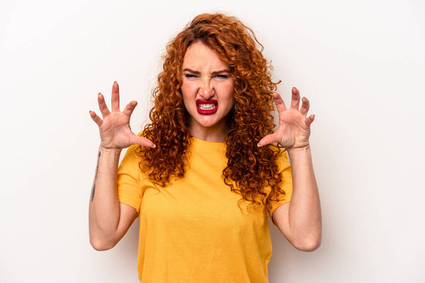 Young ginger caucasian woman isolated on white background showing claws imitating a cat, aggressive gesture. - Фото, изображение