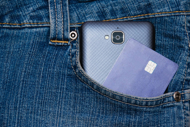 Cartão bancário e smartphone no bolso jeans close up. Conceito de negócio e dinheiro. - Foto, Imagem