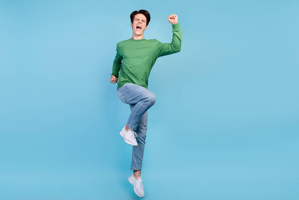 Full length body size photo guy jumping up gesturing like winner shouting loudly isolated pastel blue color background. - Foto, afbeelding