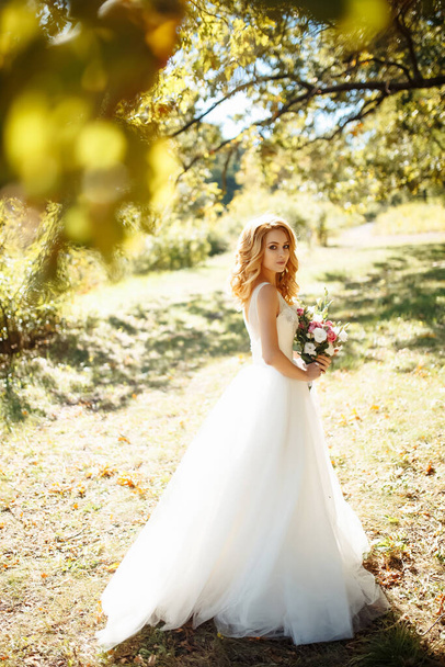 Young elegant bride in a white dress for a walk in the park.  Wedding day. Marriage. Fashion bride. - Zdjęcie, obraz